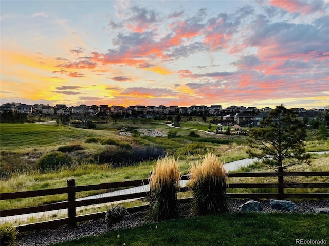 gate at dusk with fence and a residential view