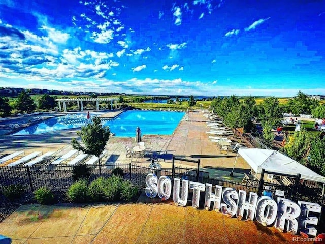 community pool with fence and a patio area