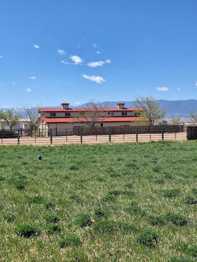 view of yard with a rural view and a mountain view