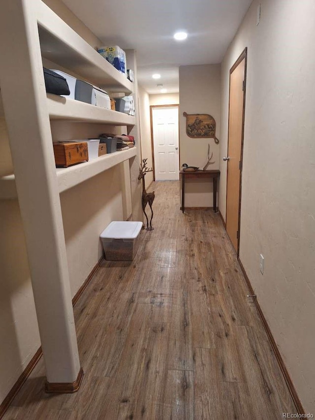 corridor with hardwood / wood-style floors