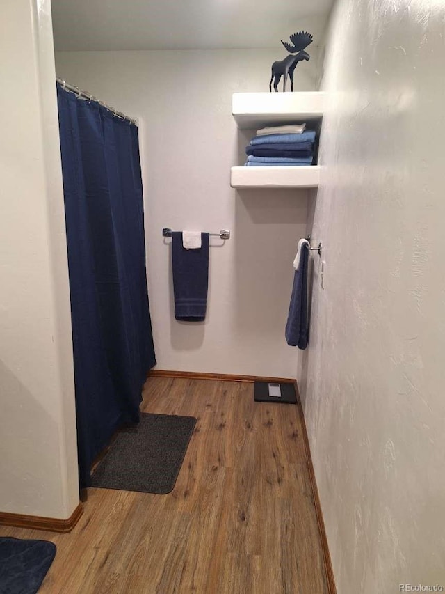 bathroom with hardwood / wood-style flooring and walk in shower