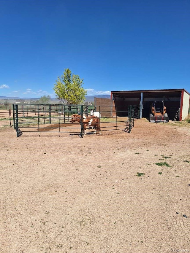 view of horse barn with a rural view