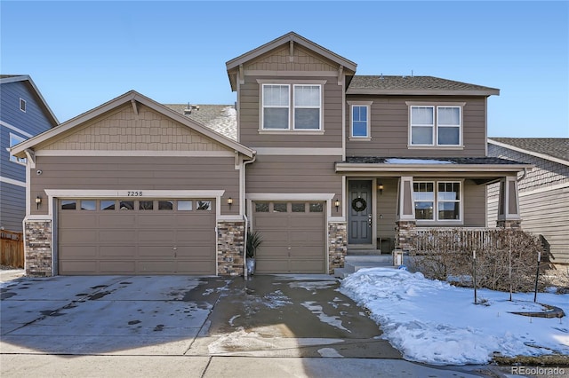 craftsman-style house with stone siding, covered porch, and concrete driveway