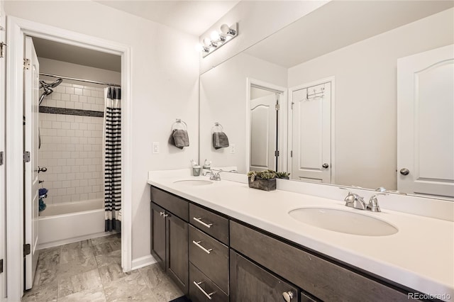 bathroom with double vanity, baseboards, shower / bath combo with shower curtain, and a sink