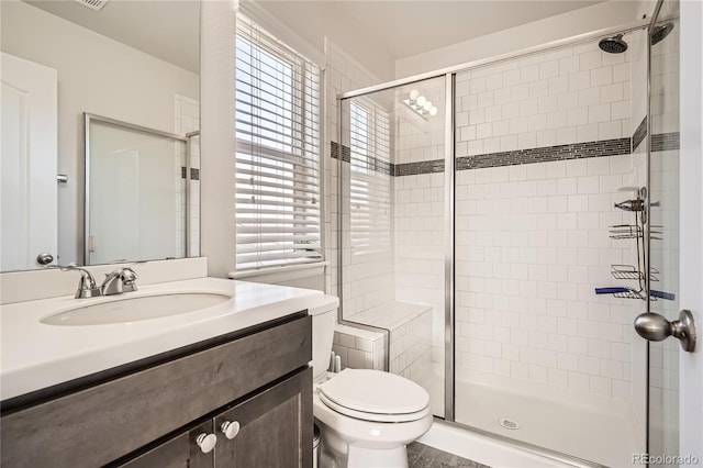 full bath with a shower stall, vanity, and toilet