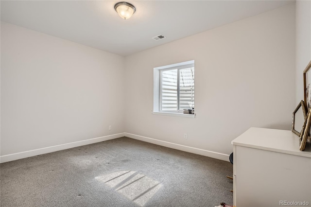 unfurnished room featuring carpet floors, visible vents, and baseboards