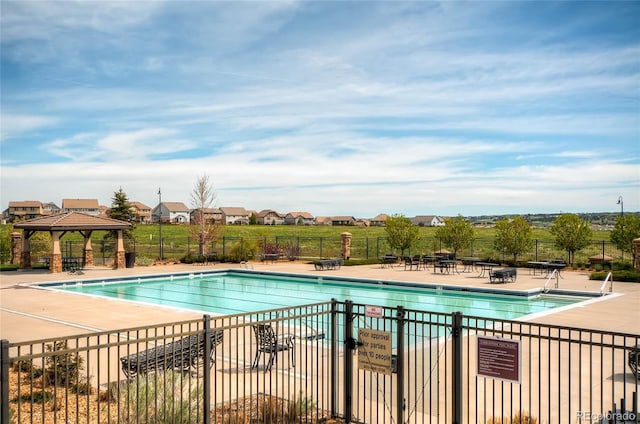 community pool featuring a residential view, fence, a gazebo, and a patio