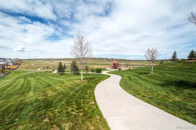 view of community with a rural view and a yard