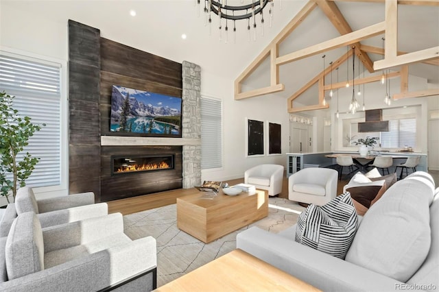 living room featuring beam ceiling, a stone fireplace, and high vaulted ceiling