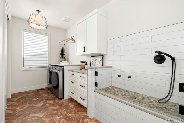 clothes washing area featuring cabinets and washer and clothes dryer