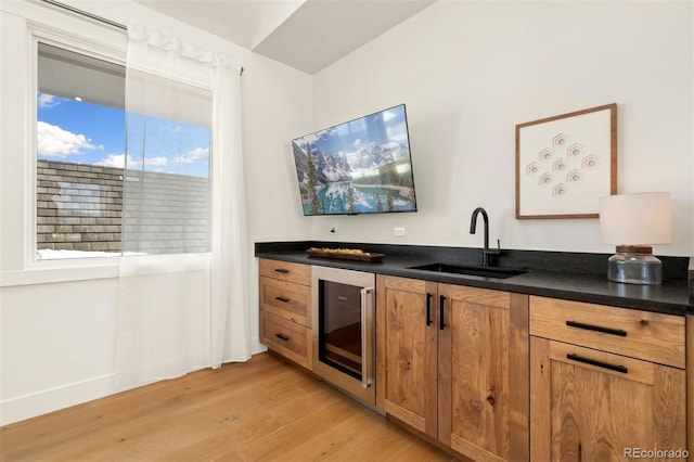 kitchen featuring wine cooler, sink, and light hardwood / wood-style floors