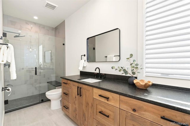 bathroom with vanity, toilet, and a shower with shower door