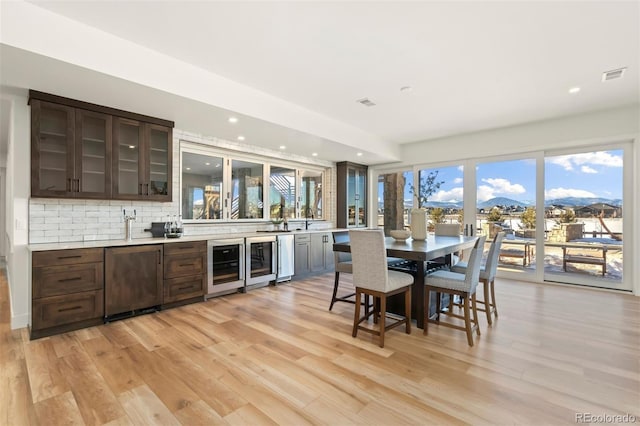 kitchen featuring wine cooler, backsplash, a mountain view, and light wood-type flooring