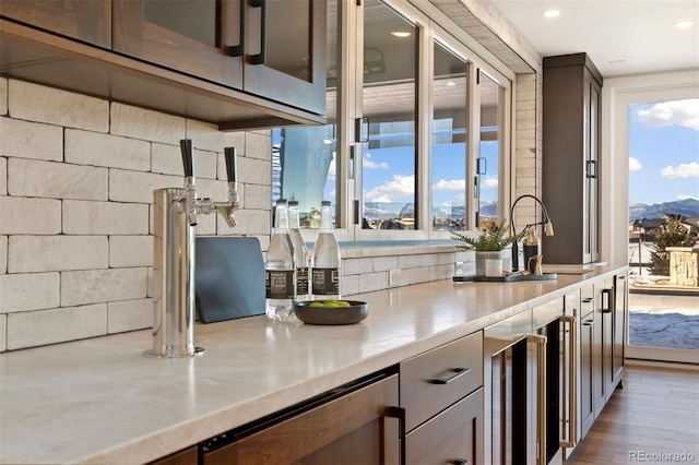 bar with a mountain view, a healthy amount of sunlight, sink, and beverage cooler