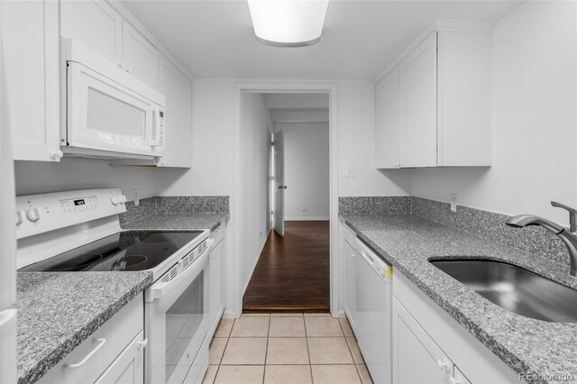 kitchen with white cabinetry and white appliances