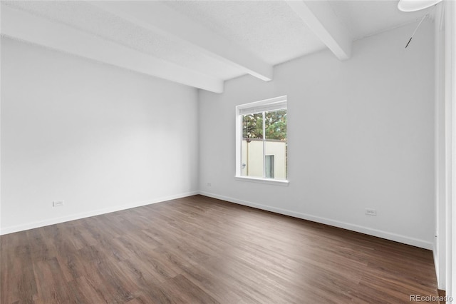 empty room featuring dark wood-type flooring, beamed ceiling, and a textured ceiling