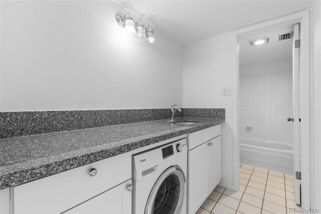 washroom featuring cabinets, washer / clothes dryer, sink, and light tile patterned floors