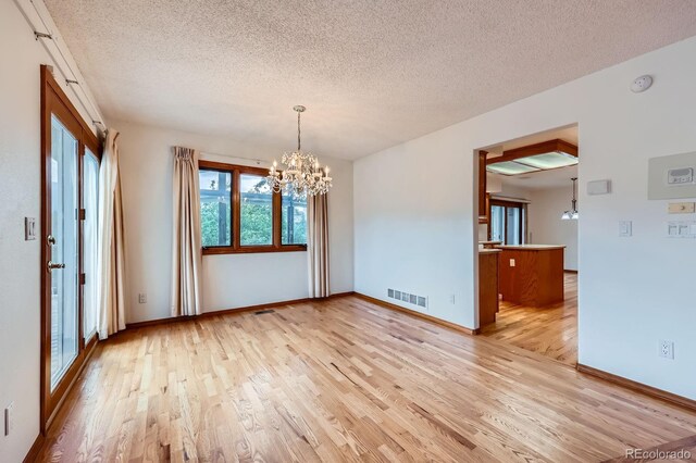 16710 Vincent Ave, Monument, CO 80132 - spare room with a chandelier, light wood-style flooring, a textured ceiling, and a smoke detector