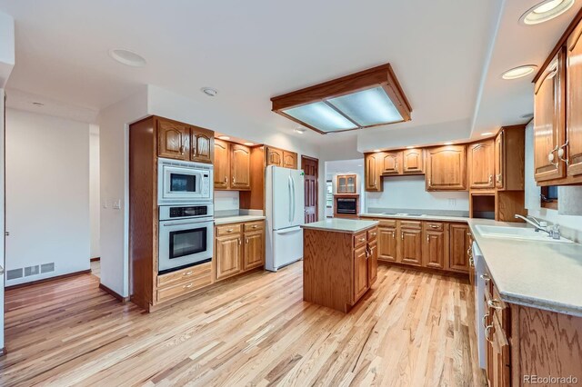 16710 Vincent Ave, Monument, CO 80132 - kitchen featuring appliances with stainless steel finishes, light wood-style flooring, a kitchen island, light countertops, and brown cabinets