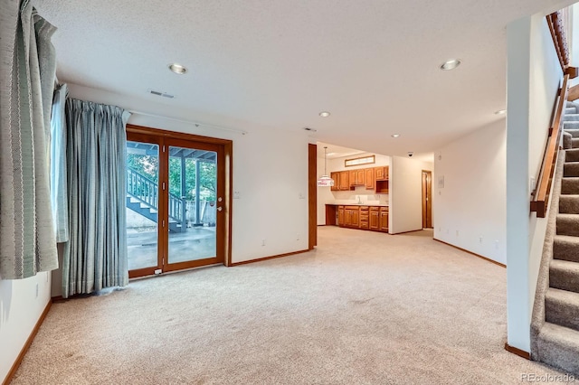 16710 Vincent Ave, Monument, CO 80132 - unfurnished living room featuring stairway, light carpet, and recessed lighting