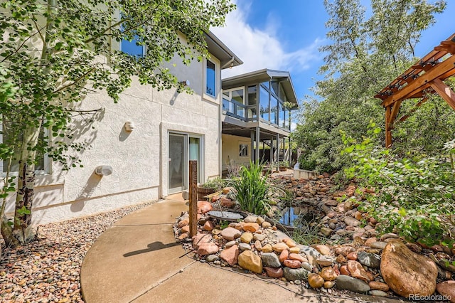 16710 Vincent Ave, Monument, CO 80132 - view of side of home featuring stucco siding, a balcony, and a patio area
