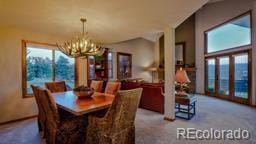 carpeted dining room featuring a notable chandelier