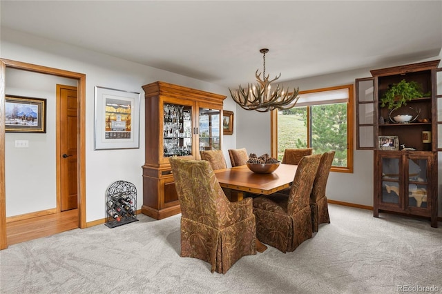 dining room featuring light carpet and an inviting chandelier