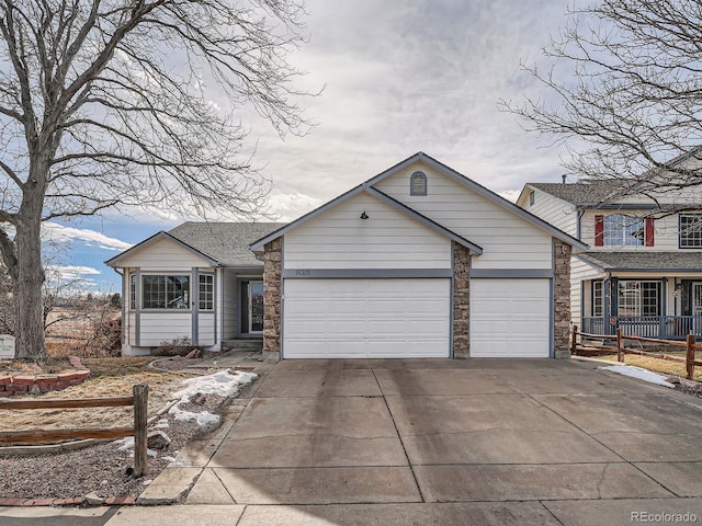 view of front facade with a garage, concrete driveway, and stone siding