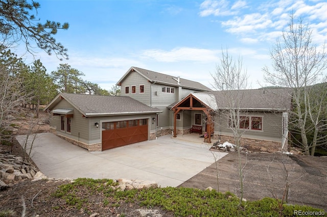 1055 Divide View Dr, Golden, CO 80403 - view of front of property featuring roof with shingles, an attached garage, concrete driveway, and stone siding