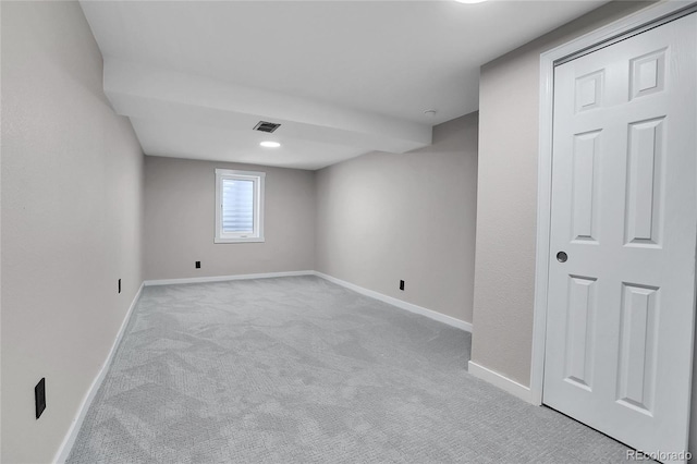 basement featuring visible vents, baseboards, and carpet