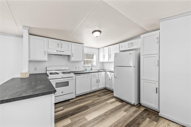 120 Pinon Dr, Hotchkiss, CO 81419 - kitchen with white appliances, under cabinet range hood, dark countertops, white cabinetry, and a textured ceiling