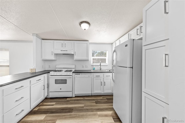 120 Pinon Dr, Hotchkiss, CO 81419 - kitchen with white appliances, a textured ceiling, dark countertops, and white cabinets