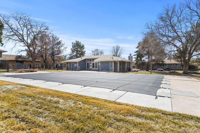 community pool with fence, a yard, and a patio area