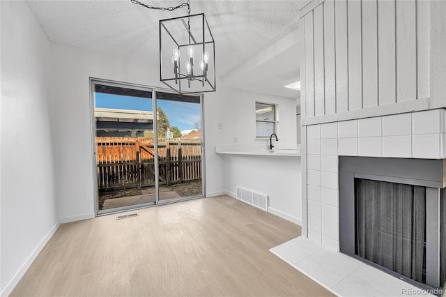 unfurnished living room with visible vents, wood finished floors, and a fireplace