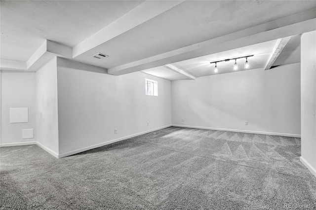 below grade area with baseboards, carpet flooring, rail lighting, and visible vents