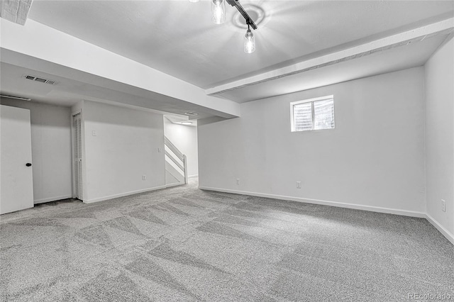 below grade area with baseboards, carpet, visible vents, and stairway