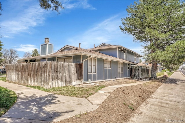 view of front of home with fence and a chimney