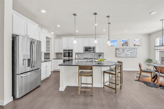 8772 S Sicily Ct, Aurora, CO 80016 - kitchen featuring stainless steel appliances, dark countertops, tasteful backsplash, wood finished floors, and recessed lighting
