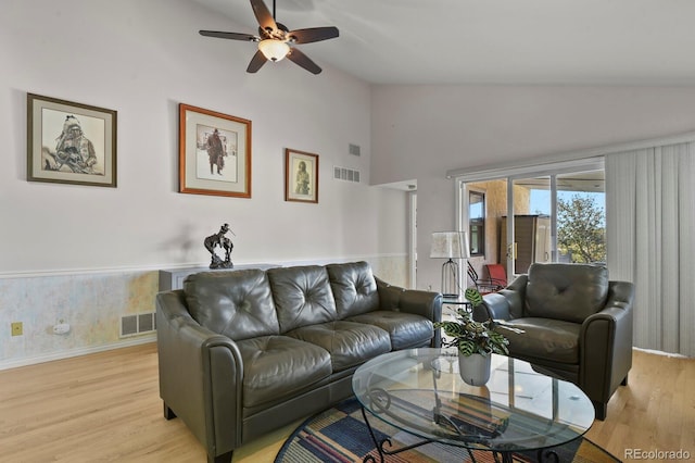 living room featuring ceiling fan, light hardwood / wood-style floors, and lofted ceiling