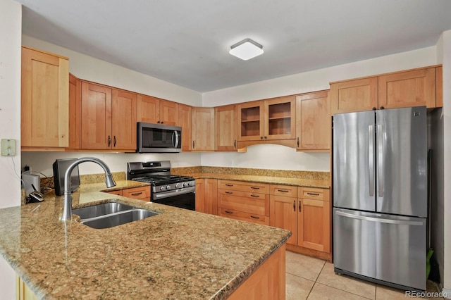 kitchen featuring sink, light tile patterned floors, light stone counters, kitchen peninsula, and stainless steel appliances