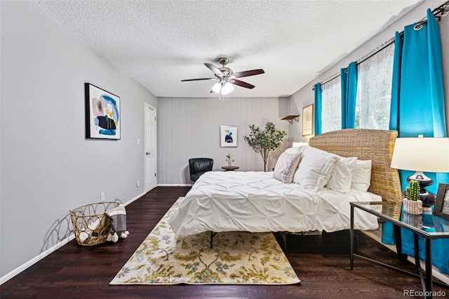 bedroom with dark hardwood / wood-style floors, a textured ceiling, and ceiling fan