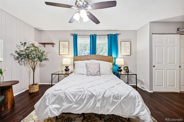 bedroom featuring ceiling fan, dark hardwood / wood-style floors, and a textured ceiling