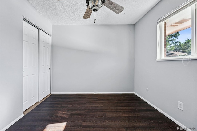 unfurnished bedroom featuring ceiling fan, a textured ceiling, a closet, and dark hardwood / wood-style floors