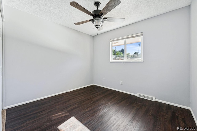 empty room featuring ceiling fan, dark wood-type flooring, and a textured ceiling