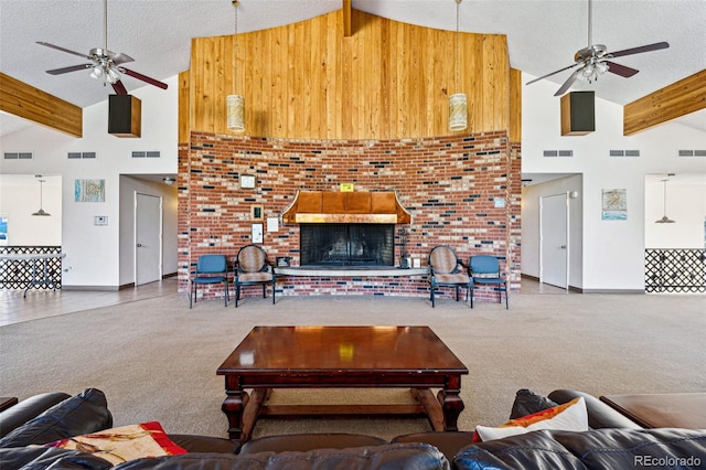 carpeted living room with ceiling fan, high vaulted ceiling, beam ceiling, and a textured ceiling