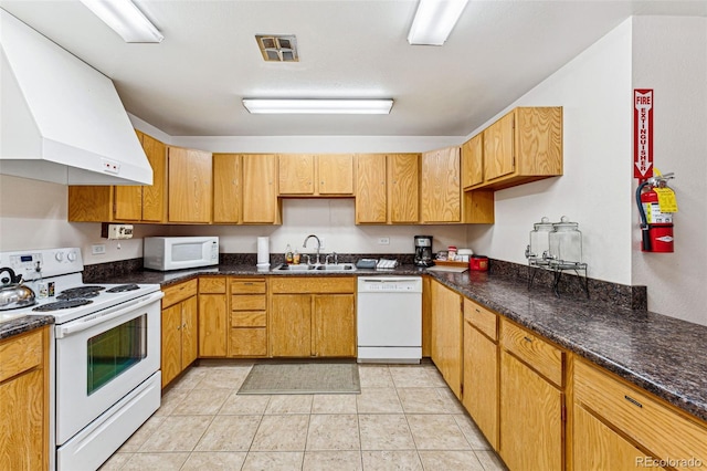 kitchen featuring light tile patterned floors, sink, white appliances, extractor fan, and dark stone counters