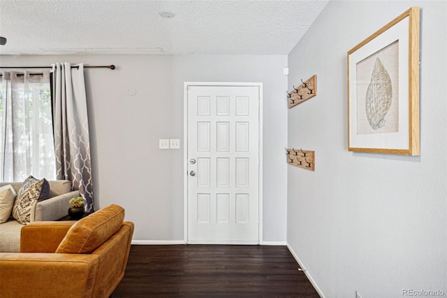 entrance foyer with dark hardwood / wood-style floors and a textured ceiling