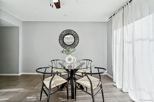 dining area with ceiling fan and a textured ceiling