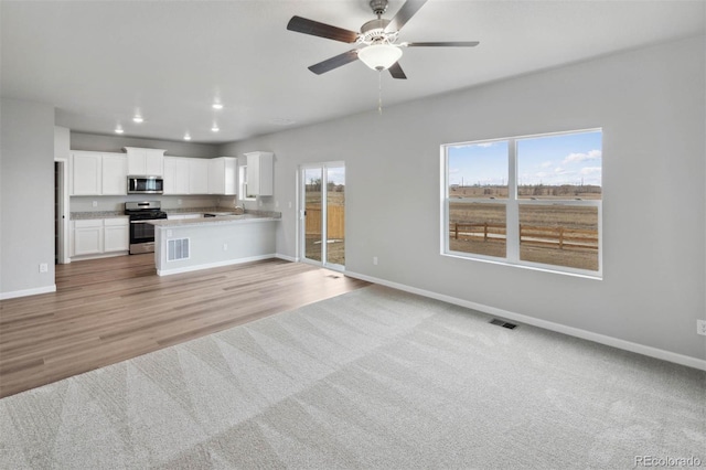 kitchen with recessed lighting, baseboards, open floor plan, and stainless steel appliances