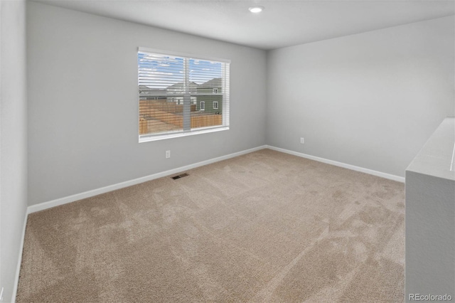 empty room featuring baseboards and carpet